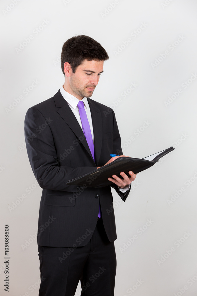Business man is writing on a notepad Business man is writing on a notepad