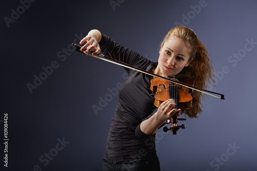 Beautiful young woman playing violin. Portrait of musician photo