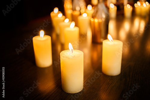 Many burning candles on a mirrored background
