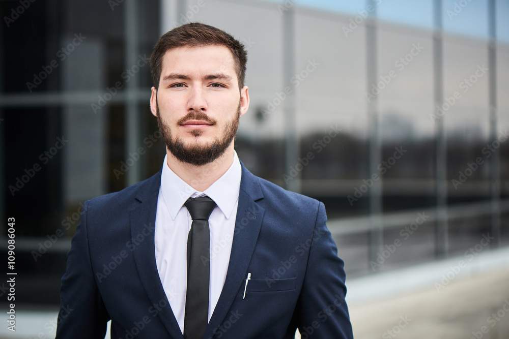 Portrait of young man in suit on the background of the building with a glass facade Portrait of young man in suit on the background of the building with a glass facade