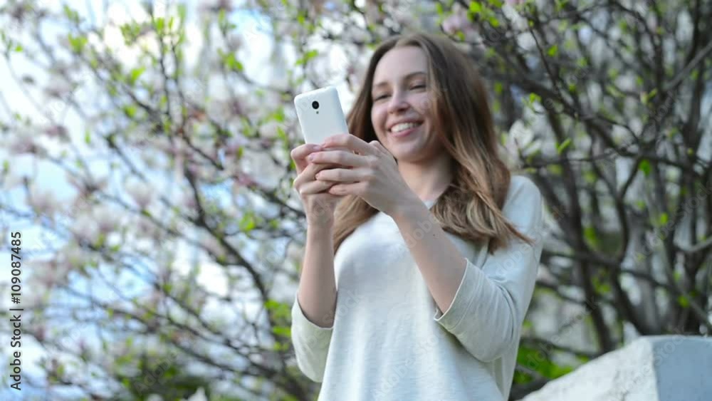 Woman using app on smartphone smiling and texting on mobile phone Woman using app on smartphone smiling and texting on mobile phone