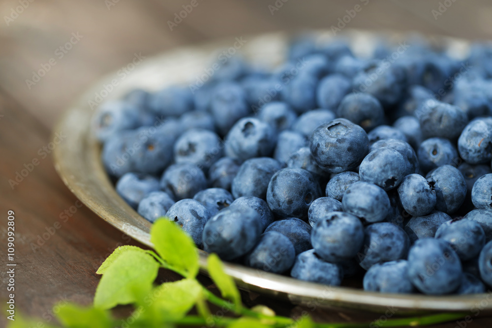 Fresh ripe blueberries outdoors on a wooden background Fresh ripe blueberries outdoors on a wooden background