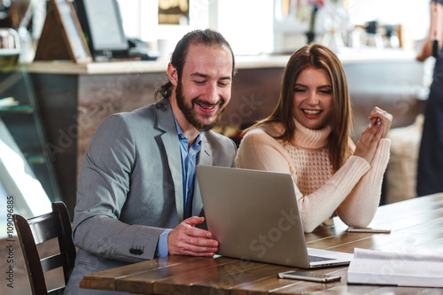 couple in a cafe looking to laptop