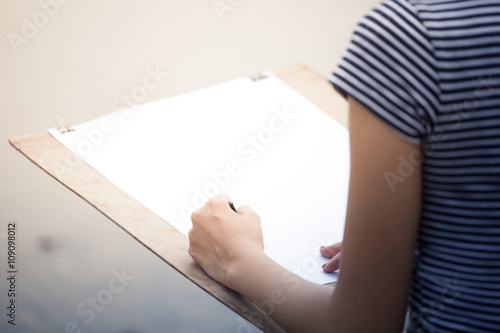 Artist girl drawing something in a paper