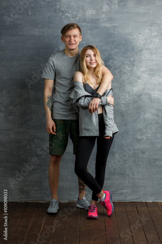 Two beautiful friends, man and girl, smiling in a gym