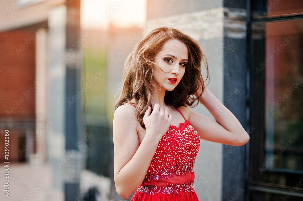 Fototapeta premium Close up portrait of fashionable girl at red evening dress posed