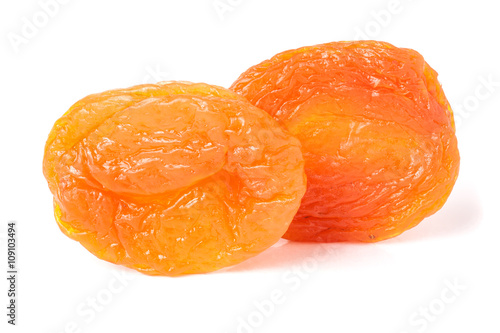 two dried apricots on a white background closeup