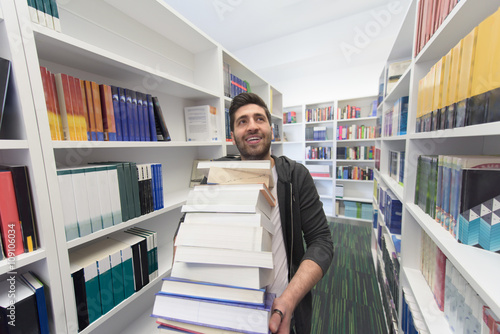 Student holding lot of books in school library