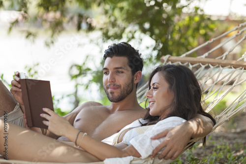 happy couple in love reading a book in hammock,selective focus
