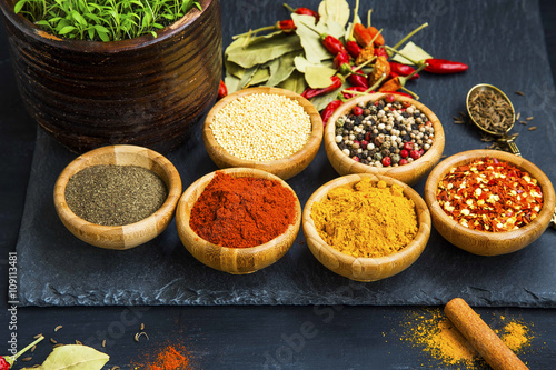 Spices powder and seeds seasoning in wooden bowls