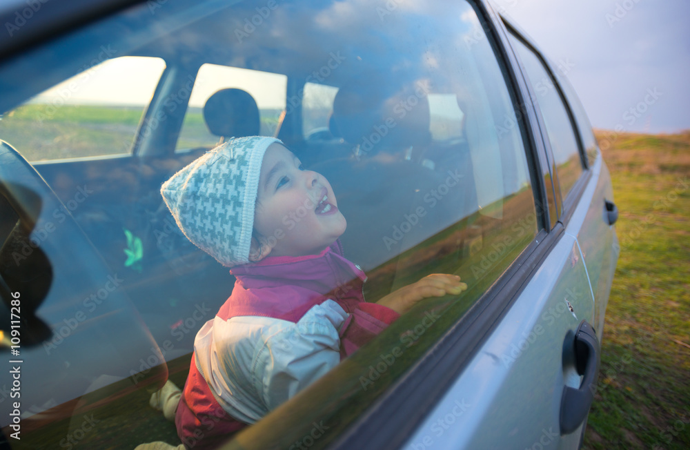 Fototapeta premium little girl in the car smiling
