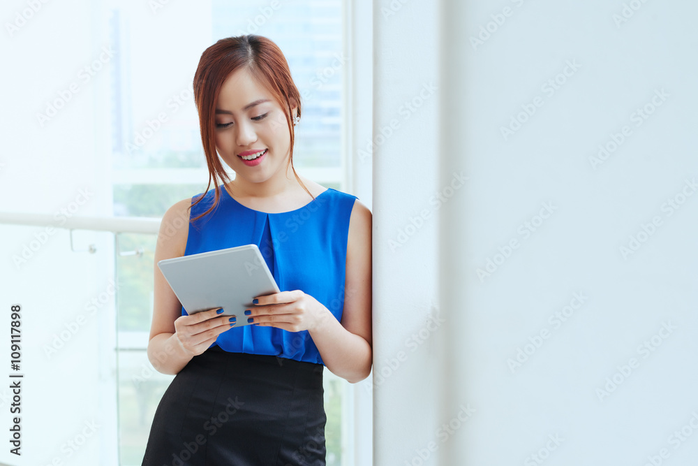 Pretty young Vietnamese business lady with digital tablet Pretty young Vietnamese business lady with digital tablet