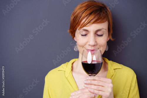 frau mit kurzen, roten haaren riecht an einem glas rotwein © contrastwerkstatt