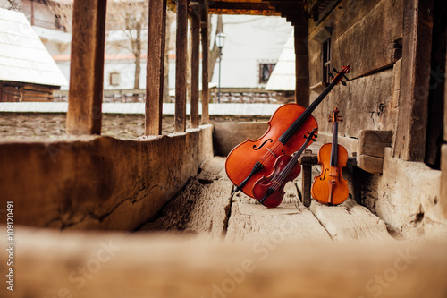 Fototapeta cello and violin leaning on a porch