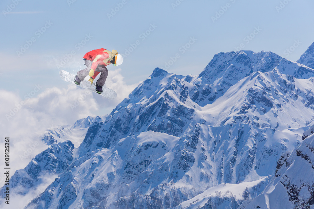 Snowboard rider jumping on mountains. Extreme snowboard freeride sport.