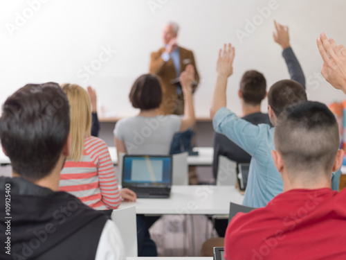 students group raise hands up on class