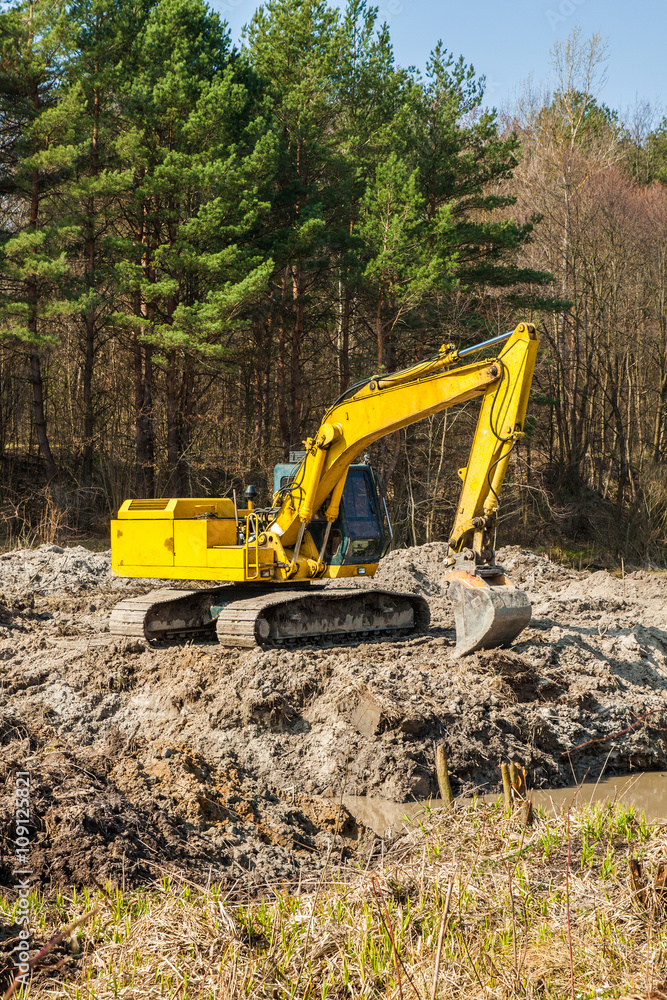 large yellow excavator Yellow on a construction site against blu sky large yellow excavator Yellow on a construction site against blu sky