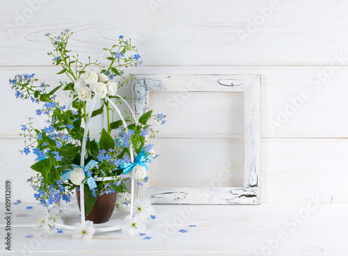 Forget-me-not flowers with birdcage and photo frame