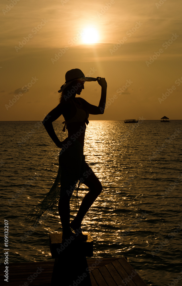Young women on the beach and enjoy the sunset