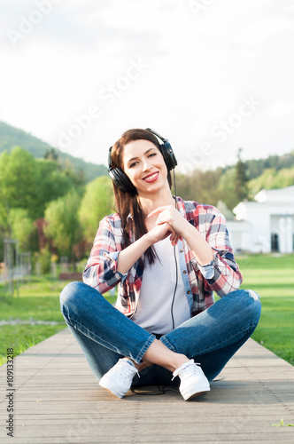 Happy woman posing and relaxing outside while listening music