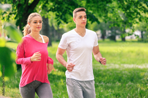 Fototapeta Naklejka Na Ścianę i Meble -  Running couple jogging in the park