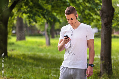 Man using mobile phone after jogging in park