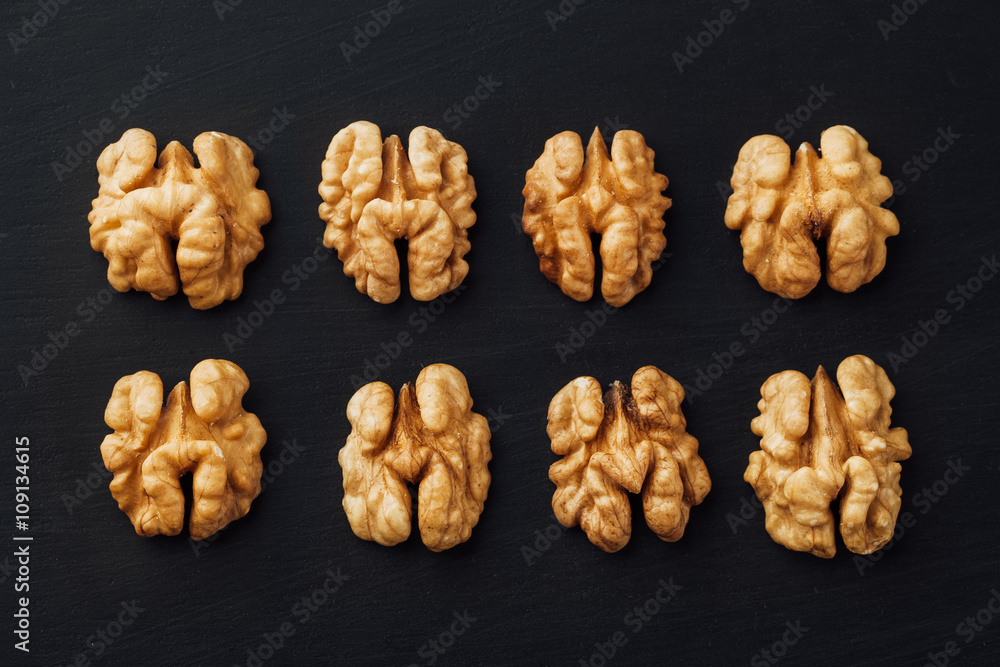 shelled walnuts in a row on black shelled walnuts in a row on black