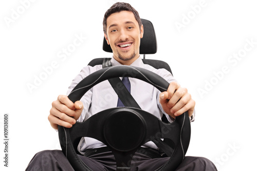 Obraz na plátně Cheerful guy holding a steering wheel