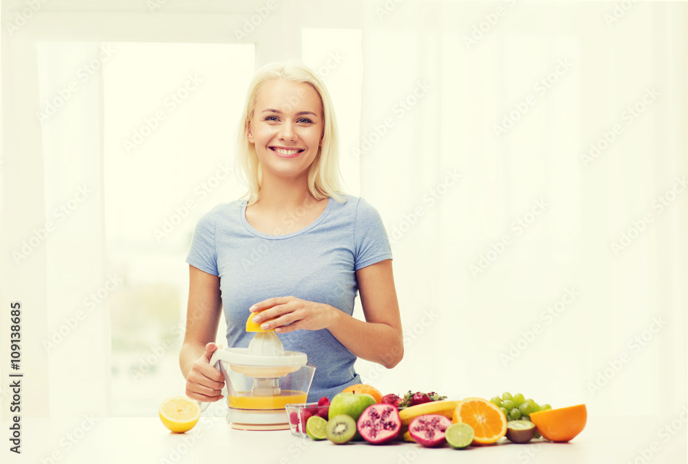 smiling woman squeezing fruit juice at home