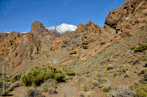 lava rock formations and snow covered peak of Teide volcano Roques de Garcia, Teide National park, Tenerife, Canary islands, Spain