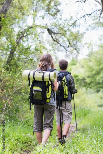 Rear view of couple hiking on field