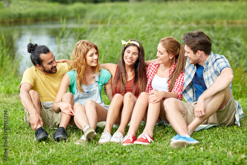 group of smiling friends talking outdoors