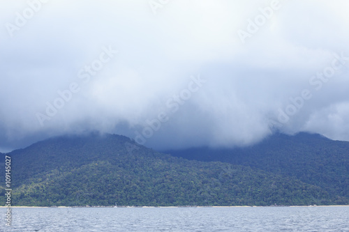 storm white cloud with rain above island and sea