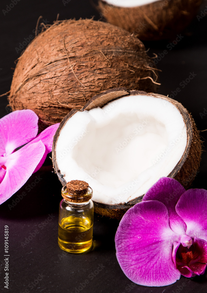 Coconut with coconut oil in jar on black background Coconut with coconut oil in jar on black background