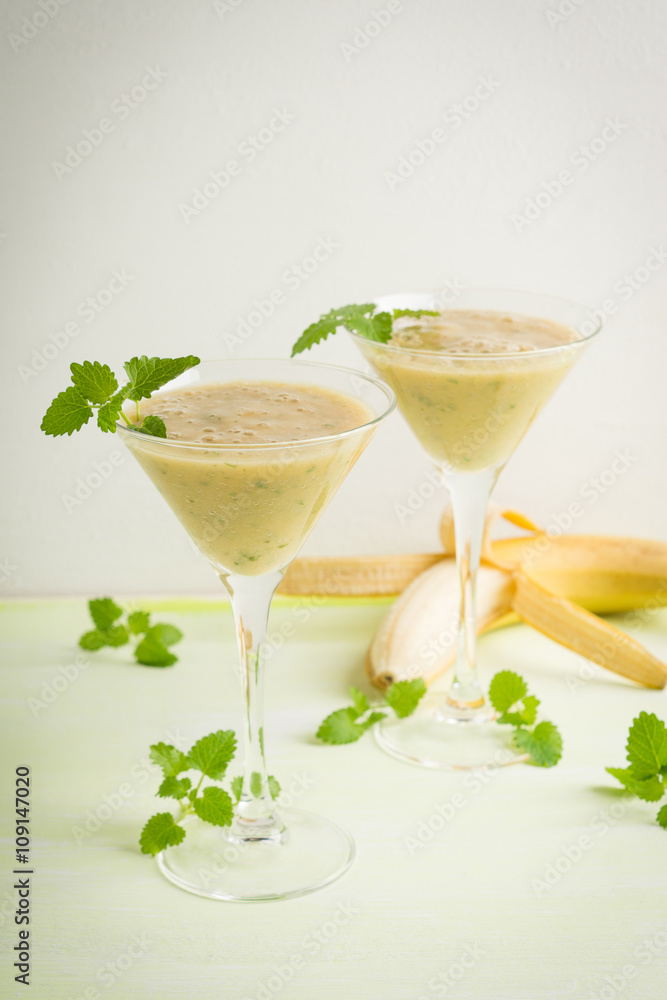 Fresh banana cocktail with mint on the wooden background Fresh banana cocktail with mint on the wooden background
