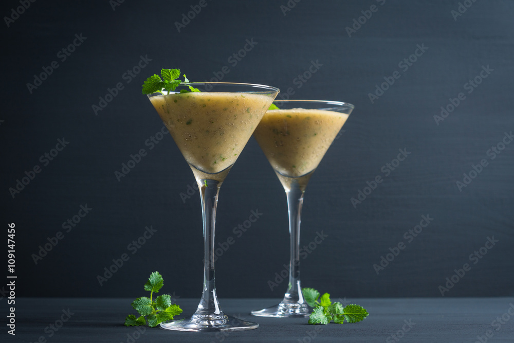 Fresh banana cocktail with mint on the black wooden background Fresh banana cocktail with mint on the black wooden background