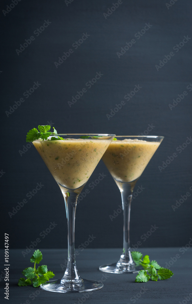 Fresh banana cocktail with mint on the black wooden background