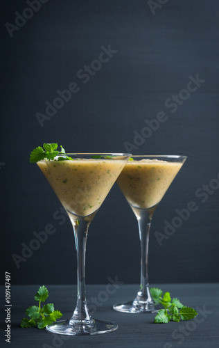 Fresh banana cocktail with mint on the black wooden background