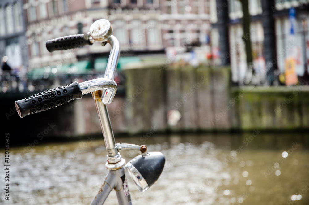 Obraz premium Bike in Amsterdam with canal in the background