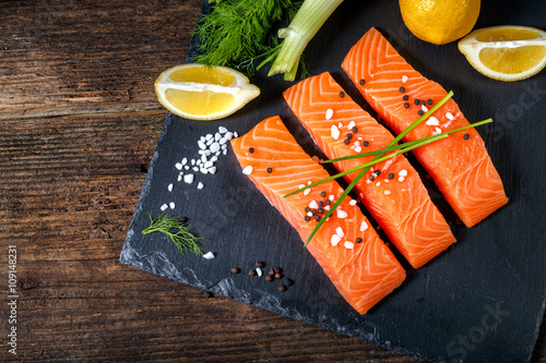 Salmon filet sliced on three parts with lime and herbs.