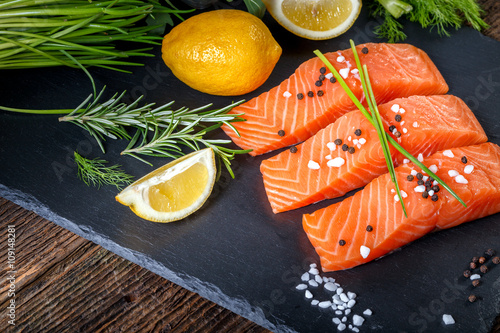 Salmon filet sliced on three parts with lime and herbs.
