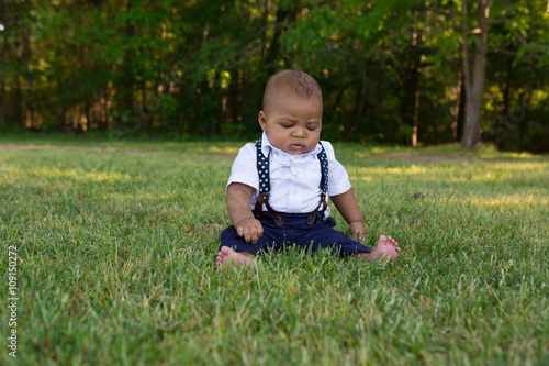 A toddler sitting in the grass