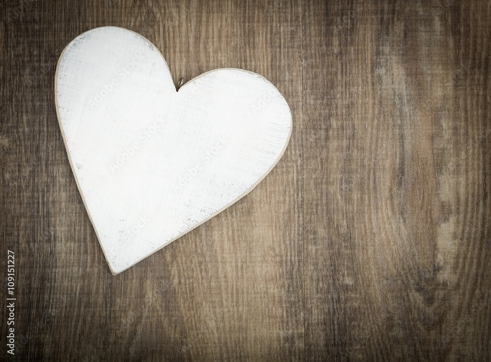 Wooden heart on brown wood plank background Wooden heart on brown wood plank background