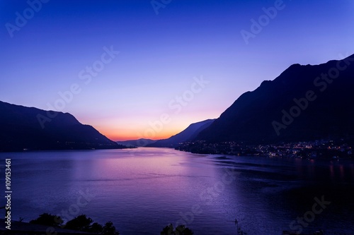 Lake with silhouetted mountains at sunset, Pognana Lario, Lombardy, Italy photo