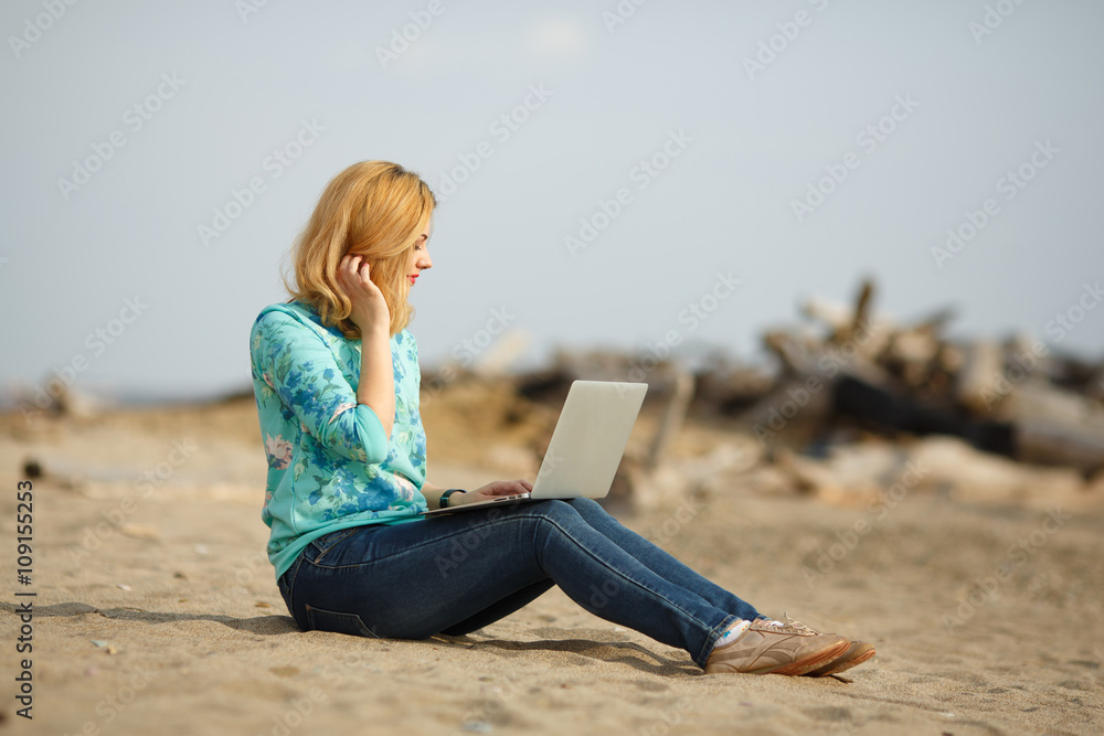 young beautiful woman working on laptop outdoors