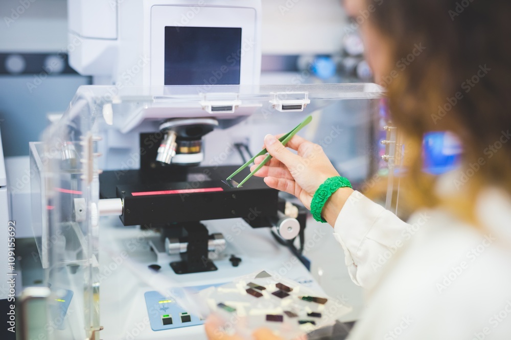 Female scientist using FTIR spectrophotometer, positioning thin film ...