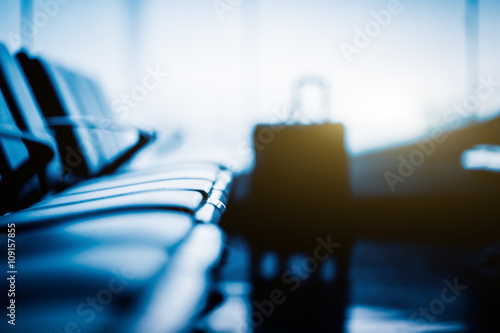 Empty seat and a luggage in airport,blue toned.