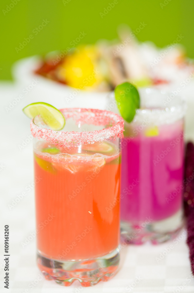 Closeup small sugarcoated shotglasses with delicious orange and purple juices inside Closeup small sugarcoated shotglasses with delicious orange and purple juices inside