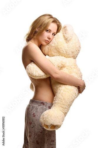 Girl in pijamas pants hugging giant plush bear  photo