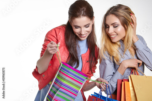 shopping, sale and gifts concept - two smiling teenage girls wit